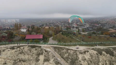 Tandem paragliding flight over a small village. Stockbeeldmateriaal 165544948