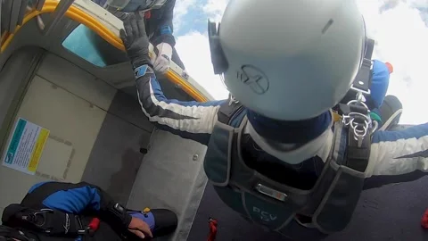 Tandem skydivers are jumping out of the airplane door. Amazing POV view Stock Footage 241559939