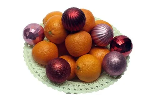 Tangerine and Christmas decorations on a plate on white background Stock Photos