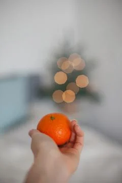 Tangerine in hand Stock Photos