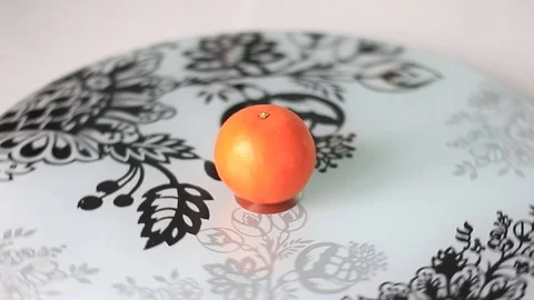 Tangerine on a rolling plate 스톡 동영상 71983181