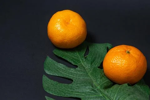 Tangerines on a black background. Citrus fruit.  Stock Photos