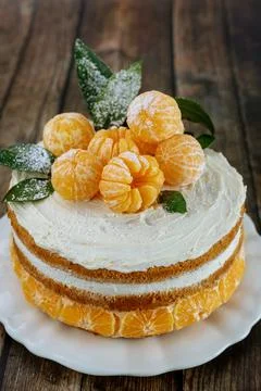 Tangerines cake with leaves on rustic background. Stock Photos