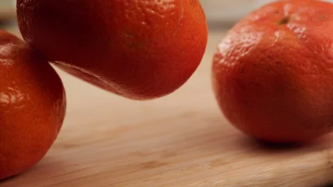 Tangerines fall on a cutting board in slow motion Stock Footage 156858809