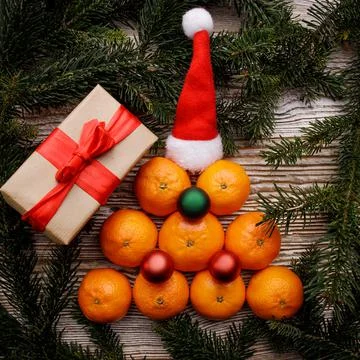 Tangerines folded on a table in the shape of a Christmas tree with decorations Foto stock