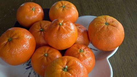 Tangerines lie in a plate on the table Stock Footage 128166519