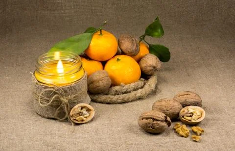 Tangerines, nuts and candle Stock Photos