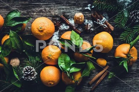 Tangerines, spices, pine cones and fir tree branches on wooden table. Stock Photos