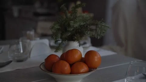 Tangerines stand on the table next to Christmas tree branches Stock Footage 232419167