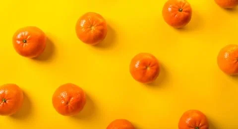 Tangerines on yellow Stock-Fotos
