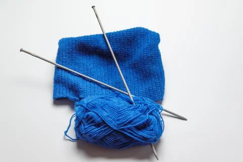 A tangle of blue yarn with two spokes threaded on a gray background. knitting Stock Photos