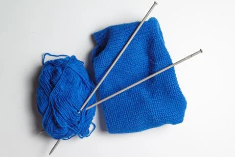 A tangle of blue yarn with two spokes threaded on a gray background. knitting Stock Photos