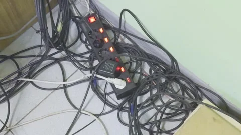 A tangle of electrical wires connected to a power strip with active indicat.. Stock Footage 311053265
