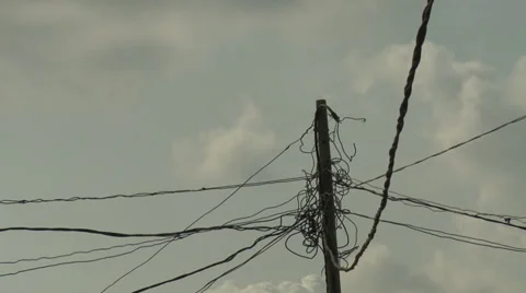 Tangle of Electricity cables on top of pole, blues sky behind Stock Footage 38481388