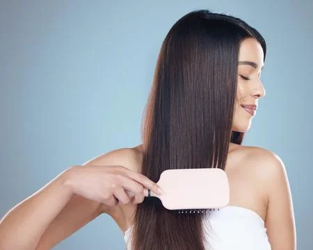 Tangle free, soft and strong. Studio shot of a beautiful young woman brushing Stock Photos