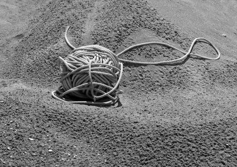 Tangle of rope lying on the sand Stock Photos