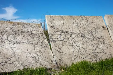 Tangled abandoned old rusty torn wire wire on a broken fence. Barbed wire fen Stock Photos