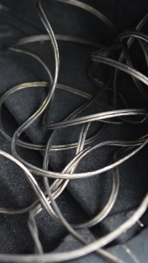 Tangled acoustic speaker wire mess lying on dark carpet floor. Stock Footage 344362403
