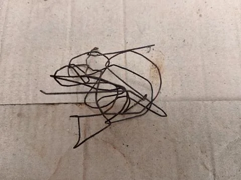 Tangled and rusty thin metal wire on a brown cardboard background. Stock Photos