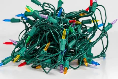 Tangled Christmas string lights turned on and isolated on white background. Stock Photos
