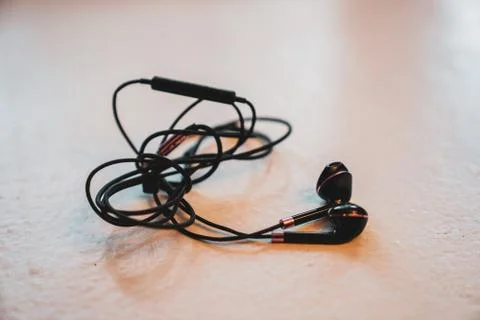 Tangled Earbuds Closeup on White Surface Stock Photos
