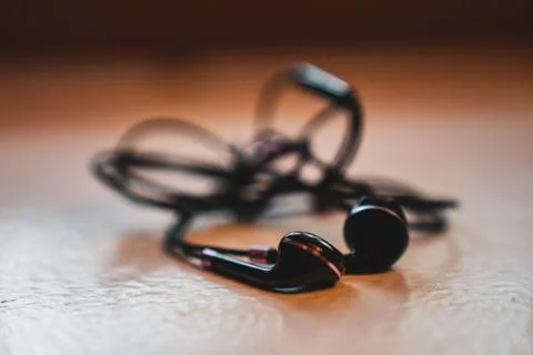 Tangled Earbuds Closeup on White Surface Stock Photos