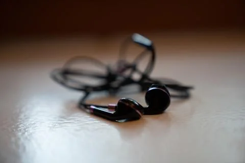 Tangled Earbuds Closeup on White Surface Stock Photos
