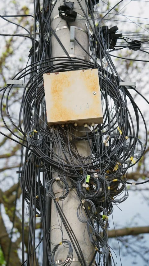 Tangled mess of communication cables and junction box on utility pole, abst.. Stock Footage 339642052