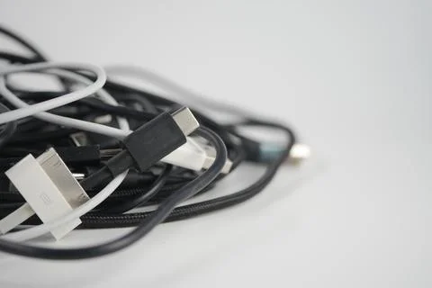 Tangled mess of cords and cables on a plain surface Stock Photos
