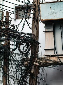 Tangled Overhead Electrical Wires on Utility Pole, Chaotic Urban Cable Mess.. Stock Photos