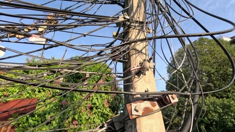 Tangled power cables and wires on a utility pole against a clear blue sky i.. Stock Footage 333873396