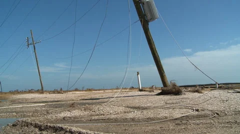 Tangled power lines on ground with tilt-up to broken lines dangling from leaning Vídeo Stock 59548319