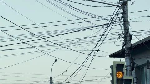 Tangled Power Lines Stretch Across Clear Blue Sky From Concrete Utility Pole Stock Footage 336092401