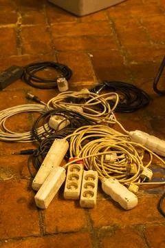 Tangled power strips and electrical cables on floor Stock Photos