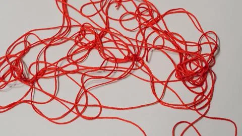 Tangled red thread on a white background, close-up view of fibers Foto stock