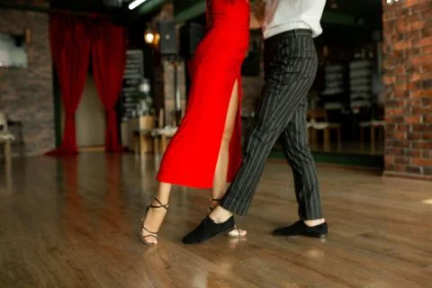 Tango couple mid-step in studio, red dress and pinstripe pants Stock Photos