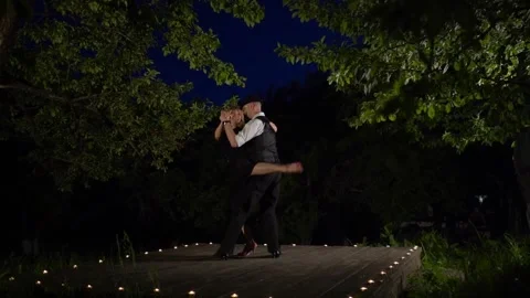 Tango dancers in the apple orchard at night. Performing latin dance on wooden Stock Footage 249092133