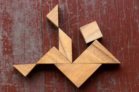 Tangram puzzle in falling man shape on red old wood background Foto stock
