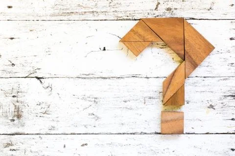 Tangram puzzle in question mark shape on old white wood background Stock Photos