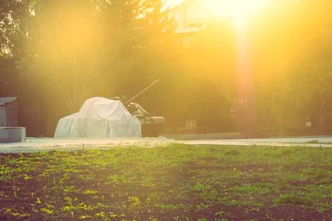 A tank covered with light material in the rays of evening backlight Stock Photos