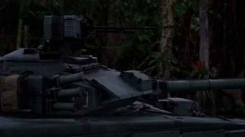 Tank maneuvering through dense jungle terrain during military operation Stock Footage 313436726