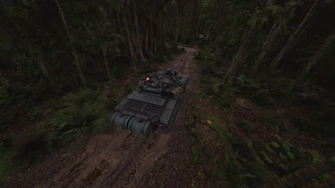 Tank navigating a jungle path surrounded by dense vegetation and trees Stock Footage 304468140