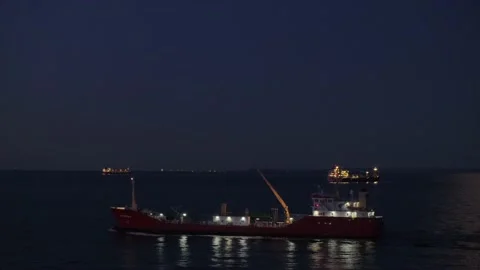Tanker with lights sails along boundless dark sea at night Stock Footage 135443467
