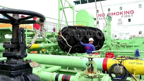 Tanker ship workers in jumpsuits operate with mooring fender Stock Footage 119034865