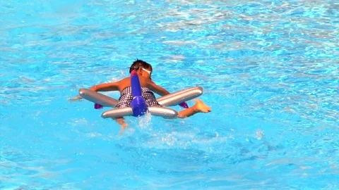 Tanned boy silhouette on inflatable float toy in blue water of swimming pool Stock-Footage 88538231
