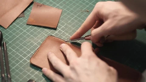 The tanner cuts off the edges of the wallet. Cuts off the ends. Edge skiving Stock Footage 104926424