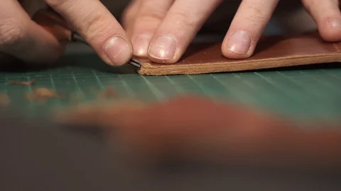 The tanner cuts off the edges of the wallet. Cuts off the ends. Edge skiving Stock Footage 104926508
