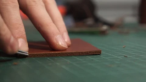 The tanner cuts off the edges of the wallet. Cuts off the ends. Edge skiving Stock Footage 104926534