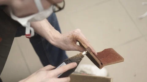 The tanner, with the help of Dremel, polishes the edges of leather goods. Close Stock Footage 104927140
