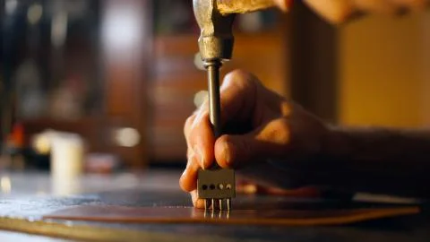 Tanner makes hole in workpiece. Stock Photos